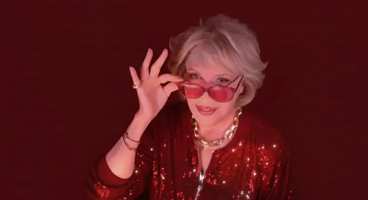 Amanda Lear, 70s music legend, wearing a red sequin jacket and gold necklace.