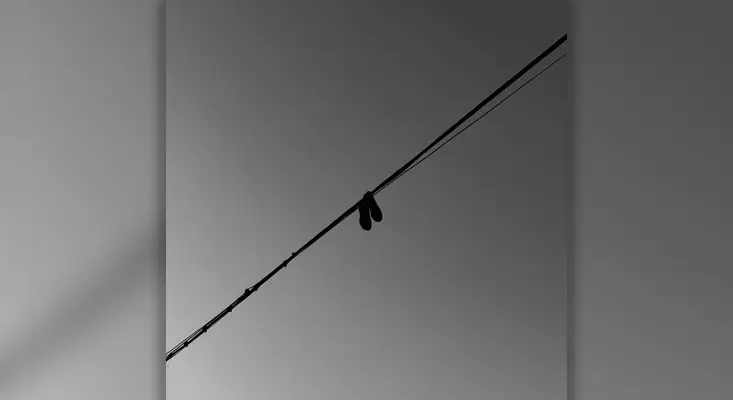 Official cover art for FATAL ATTRACTION by ero808, featuring shoes hanging from a wire in a moody, grayscale sky.