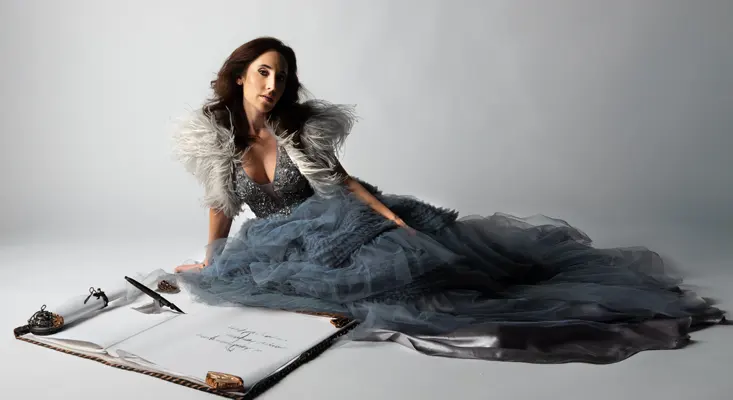 Singer Stefanie Michaela in a blue gown with her "Turning Pages" journal.