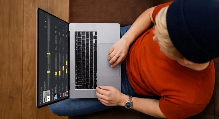 Person browsing the Epidemic Sound music licensing platform on a laptop.