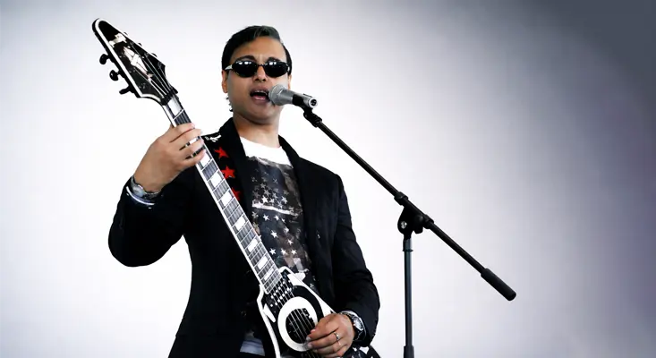 Quonrocker playing a Gibson Custom Shop Flying V while singing into a microphone during the Crazy Train Ozzy Osbourne cover music video