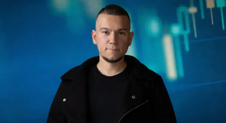 Roman Messer wearing a black jacket against a blue celestial background for his Trance single Odyssey.