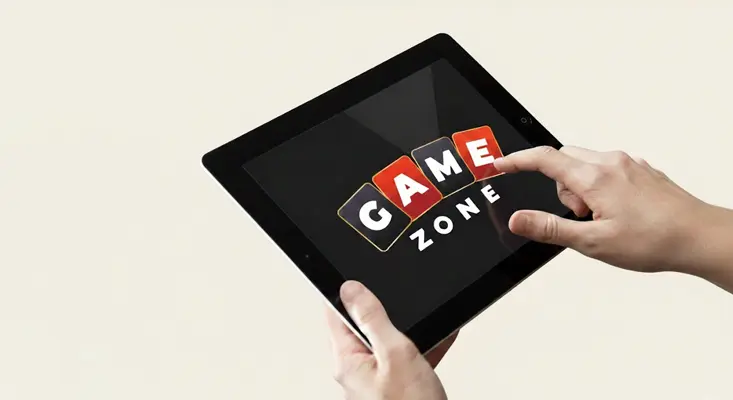 Hands tapping the GameZone logo on a tablet screen to access GameZone Arcade Games.