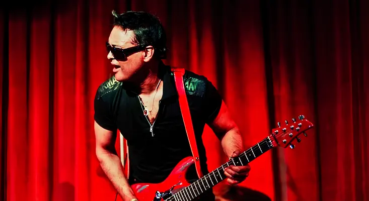 Quonrocker performing an epic guitar cover of Perry Mason by The Prince Of Darkness Ozzy Osbourne on stage with a red guitar.