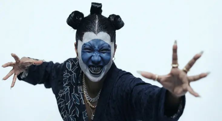A lady with dark blue and white face paint performing a dark geisha dance in Sian and Sam Wolfe's Another Pill music video.
