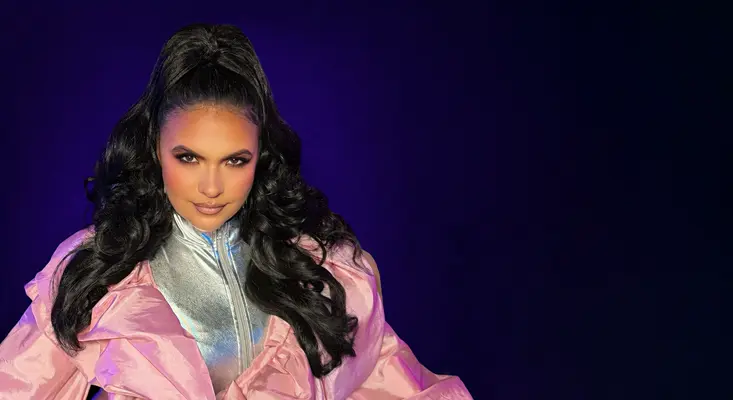 Australian singer VASSY posing in a disco-inspired silver and pink outfit, representing the sound of funky songs from the 70s for her single On Me.