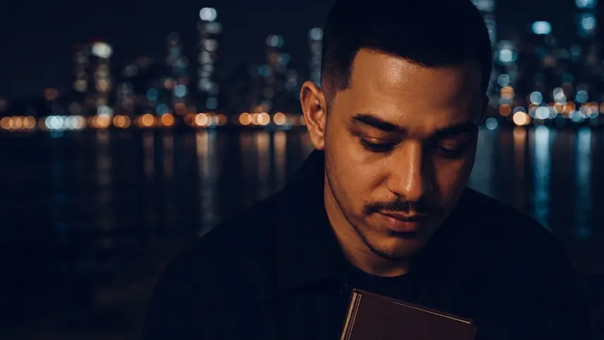 Jamie Birch reflects on how songwriting shapes his storytelling for 'CONFESSIONS.' Jamie Birch reading a notebook by the city skyline while reflecting on his songwriting process.