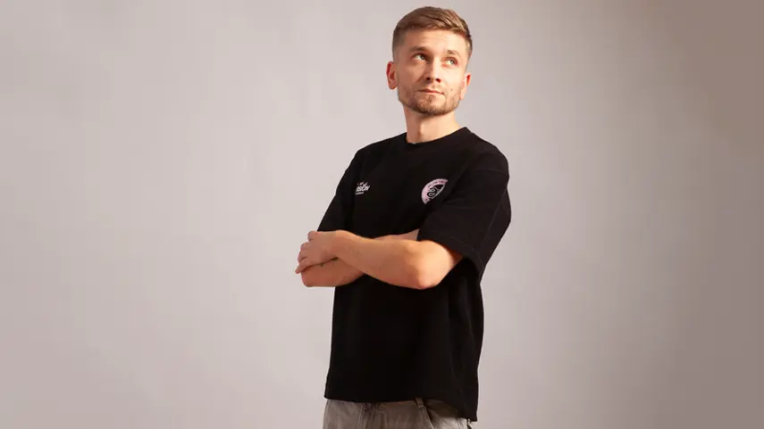 R. Dabizha Talks Melodic, Organic House Plus New Single “Talia” R. Dabizha poses with arms crossed in black t-shirt for Talia interview.