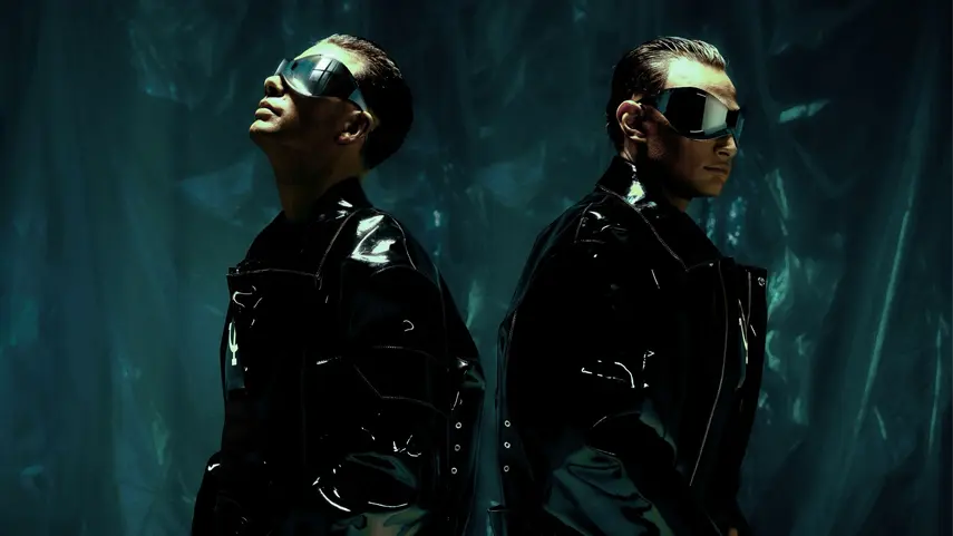 German Electronic Music Duo twocolors Drop “Heart 2 Heart” German electronic music duo twocolors wearing futuristic sunglasses and glowing neon chest pieces in a crowd from the Heart 2 Heart music video.