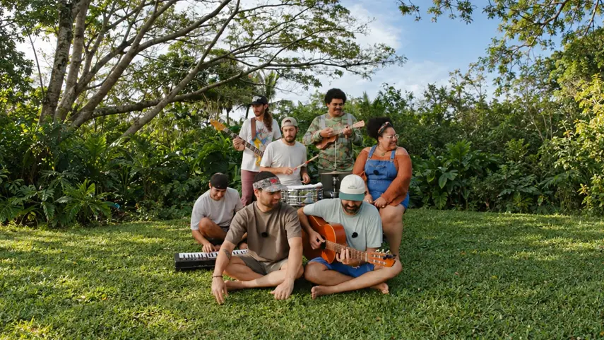ANYKINEʼs “Inertia” Remix Goes From Reggae To Electronic Heat ANYKINE band members playing guitars, drums and keyboard on the grass in a lush tropical garden for the Inertia remix.