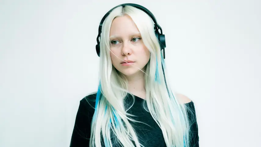LA-based producer DJ_Dave wearing black headphones against a white background for her single Next to U.