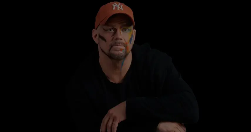 Swedish Pop artist COY Swede wearing a NY baseball cap with colorful face paint in a music video screenshot for his song Circles Round This Town.
