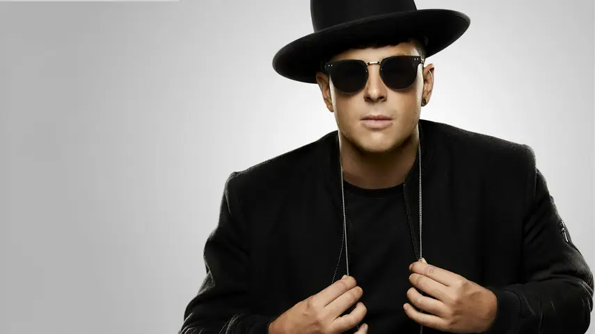 Timmy Trumpet Unveils Tracklist For His Album ‘REVELATIONS’ Timmy Trumpet wearing a black hat and sunglasses, promoting his new album REVELATIONS.