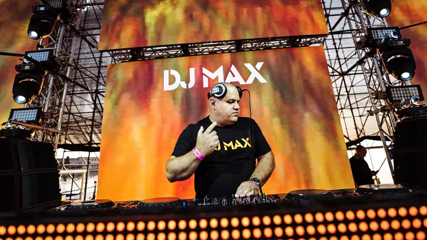 DJ MAX at the decks in a black DJ MAX t-shirt, first winner of the Ambassador award for Best Radio Show.